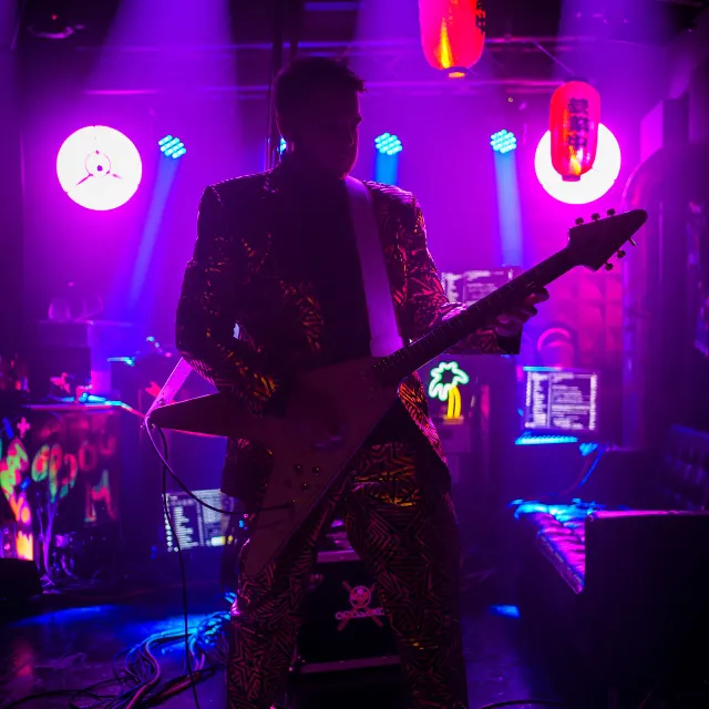 Lord Discomort s gitarou vo fialovom svetle